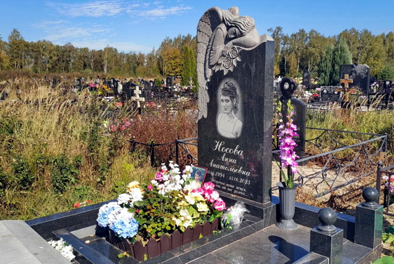 Верхняя часть скульптуры ангела на гранитном надгробье
